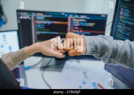 asiatische und indische Entwicklerteams klatschen Hand für Projekterfolg mit Software-Computer im Büro Stockfoto