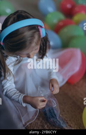 Geburtstag meiner 5-jährigen Tochter. Sie hört Musik über Kopfhörer und sammelt ein Puzzle. Hochwertige Fotos Stockfoto