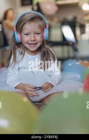 Geburtstag meiner 5-jährigen Tochter. Sie hört Musik über Kopfhörer und sammelt ein Puzzle. Hochwertige Fotos Stockfoto