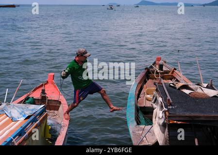 Phu Quoc, Vietnam 17. Mai 2018 - lokaler Fischer springt in der Mitte des Kampfes zum benachbarten Fischerboot im Fischerdorf Ham Ninh. Stockfoto