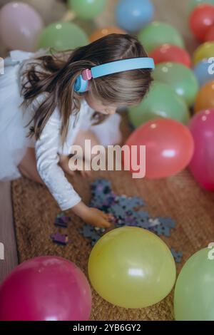 Geburtstag meiner 5-jährigen Tochter. Sie hört Musik über Kopfhörer und sammelt ein Puzzle. Hochwertige Fotos Stockfoto