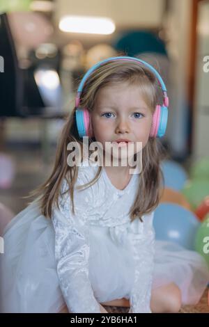 Geburtstag meiner 5-jährigen Tochter. Sie hört Musik über Kopfhörer und sammelt ein Puzzle. Hochwertige Fotos Stockfoto