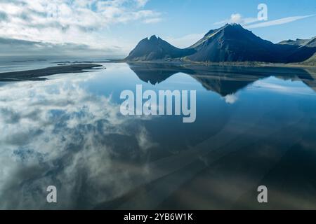 Aus der Vogelperspektive über das ruhige Meer zum Mt. Brunnhorn und Vestrahorn, östlich von Höfn, Reflexionen auf dem Meer, Ostfjorde, Island Stockfoto