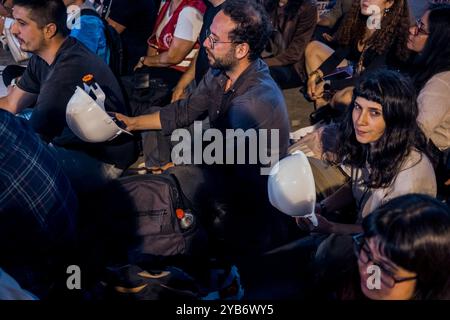 Izmir, Türkei. Oktober 2024. Die Leute unterstützen das Sit-in, indem sie die Schutzhüte der Bergleute halten, die sie während des Protestes gesehen haben. Die Bergbauarbeiter von Fernas im Stadtteil Soma in Manisa wurden von ihren Arbeitsplätzen entlassen, weil sie sich gewerkschaftlich organisieren wollten. Am 14. Oktober traten die Arbeiter in den Hungerstreik von Manisa in die Hauptstadt Ankara. Am nächsten Tag in der Nacht sperrte die Polizei die Arbeiter ein. Diese Aktion der Arbeiter fand in der ganzen Türkei Reaktion. Izmirs politische Parteien und Gewerkschaften organisierten eine Sit-in- und Pressemitteilung, die die Bergarbeiter unterstützte. Quelle: SOPA Images Limited/Alamy Live News Stockfoto