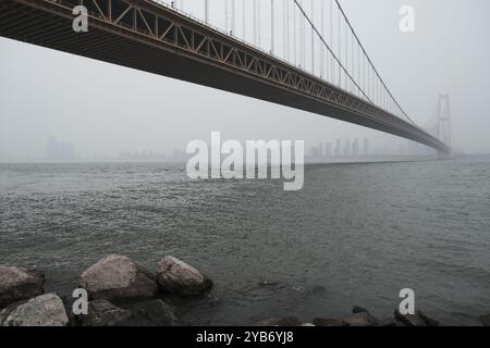 Yangsigang Yangtze River Bridge in Wuhan, Hubei, China. Lange Hängebrücke über dem Yangtse Fluss im Nebel. Flachwinkelansicht Stockfoto