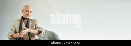 Eine junge kahlköpfige Frau mit Alopezie strahlt Selbstvertrauen aus, elegant gekleidet, während sie sich drinnen entspannt. Stockfoto