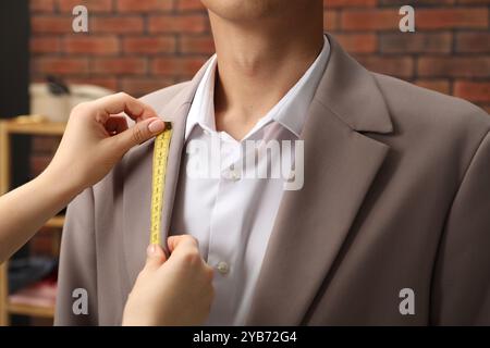 Professionelles Schneiderjacke Revers am Kunden im Atelier, Nahaufnahme Stockfoto