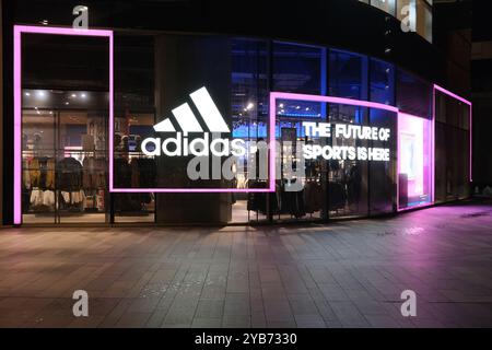 Shanghai, China - Dez. 18. 2022: adidas Sportgeschäft mit Firmenlogo bei Nacht. Stockfoto