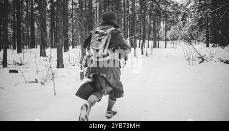 Als amerikanischer Infanterie-Soldat gekleidet, wird er angegriffen. Us-Soldaten-Angriff Im Winterwald. Soldaten Der Us-Armee Aus Dem Zweiten Weltkrieg Stockfoto