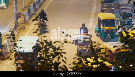 Neu-Delhi, Delhi, Indien. Verkehr auf der Hauptbasarstraße Straße Paharganj. Autos, Motorräder, Auto Rikscha oder Tuk-Tuk, die nachts auf der Straße unterwegs sind Stockfoto