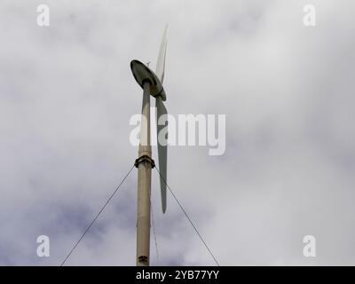 Windkraftanlage mit zwei Flügeln und bewölktem Himmel, Windkraft und sauberes Energiekonzept Stockfoto