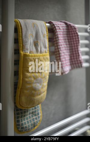 Küchenherd Handschuhe und Geschirrtuch auf Trockenregal in der Küche, matlock, derbyshire, england Stockfoto