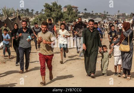 Al Mawasi, Palästinensische Gebiete. Oktober 2024. Vertriebene Palästinenser streben nach Nahrungsmittelhilfe, da die humanitäre Hilfe der Emirate im Gebiet Al-Mawasi westlich von Khan Yunis im südlichen Gazastreifen aus Flugzeugen mit Fallschirmen landet. Abed Rahim Khatib/dpa/Alamy Live News Stockfoto