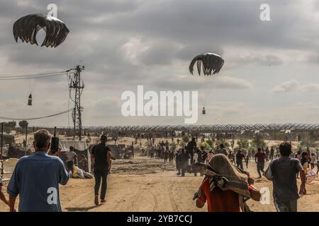 Al Mawasi, Palästinensische Gebiete. Oktober 2024. Vertriebene Palästinenser streben nach Nahrungsmittelhilfe, da die humanitäre Hilfe der Emirate im Gebiet Al-Mawasi westlich von Khan Yunis im südlichen Gazastreifen aus Flugzeugen mit Fallschirmen landet. Abed Rahim Khatib/dpa/Alamy Live News Stockfoto