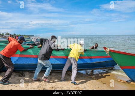 Fischer schieben ein Boot in den Viktoriasee in Kasensero, Uganda Stockfoto