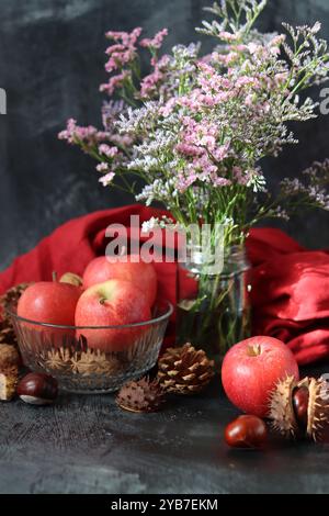 Saisonale Komposition mit Kastanien, roten saftigen Äpfeln und Nüssen auf grauem Hintergrund mit Platz für Text. Harvest Festival Konzept. Stockfoto