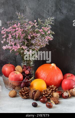Saisonale Komposition mit Kastanien, roten saftigen Äpfeln und Nüssen auf grauem Hintergrund mit Platz für Text. Harvest Festival Konzept. Stockfoto