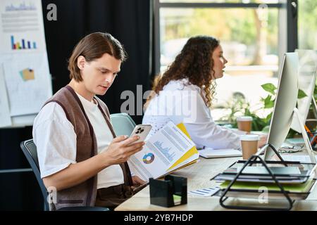 Eine junge Frau und ihr männlicher Freund konzentrieren sich auf ihre Aufgaben in einer stilvollen Büroumgebung. Stockfoto