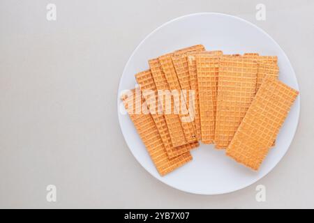 Waffeln mit Schokoladenüberzug. Belgisches Dessert. Waffeln auf Keramikplatte auf beigefarbenem Hintergrund. Draufsicht. Stockfoto