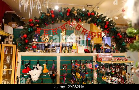 Geschmückter weihnachtsbaum im Supermarkt. Verstauen Sie Zähler mit Süßigkeiten und Marzipan auf dem Hintergrund. Weihnachtseinkaufskonzept. Bild mit selektivem Fokus Stockfoto