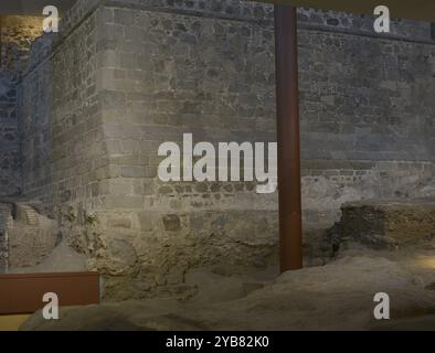 Alcázar von Toledo. Mudéjar Aquädukt. Am Fuße des Turms aus der Trastamara-Zeit befinden sich die Überreste eines Wasserkanals, der von der Innenseite des Absturzes des Alcázar aus vor dessen Bau Ende des 14. Jahrhunderts führte. Entlang des Kanals verlief eine Struktur aus Mauerwerk und Ziegelschichten, die um das 13. Jahrhundert errichtet wurden. Dieser Bau war Teil eines Mudéjar-Aquädukts, das nicht erhalten wurde und aus acht viereckigen Ziegelpilastern bestand. Armeemuseum. Toledo, Spanien. Stockfoto