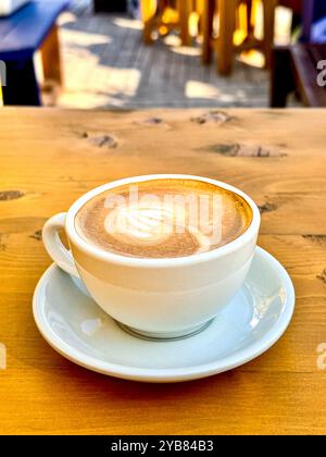 Weiße Tasse mit Cortado-Kaffee - auf einem Holztisch. Keine Person Stockfoto
