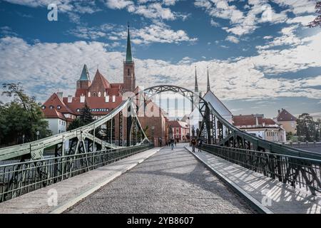 Fesselnder Blick auf eine historische Brücke, die zu einer majestätischen Kathedrale führt. Die malerische Architektur bildet einen wunderschönen Kontrast zum hellblauen Himmel Stockfoto