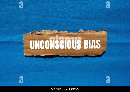 Unbewusste Vorurteilsmeldung auf zerrissenem Papppapier mit blauem Hintergrund. Konzeptuelles unbewusstes Vorurteil-Symbol. Kopierbereich. Stockfoto