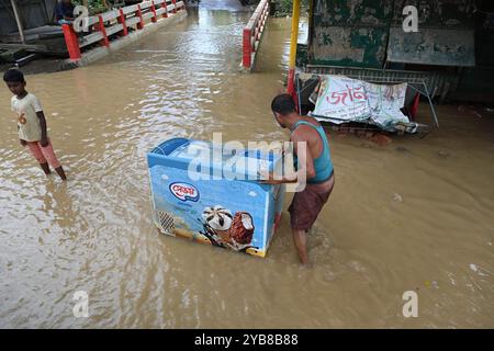 Menschen waten am 27. August 2024 durch Überschwemmungen im Bezirk Feni, Bangladesch. Stockfoto