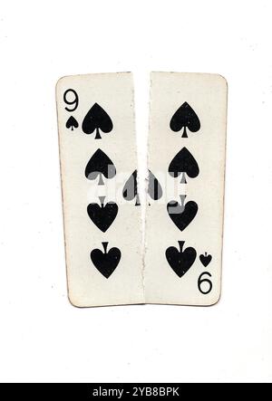 Eine alte Spielkarte, die von oben nach unten in zwei Hälften auf weißem Hintergrund zerrissen wurde. Stockfoto
