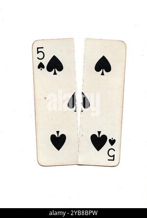 Eine alte Spielkarte, die von oben nach unten in zwei Hälften auf weißem Hintergrund zerrissen wurde. Stockfoto
