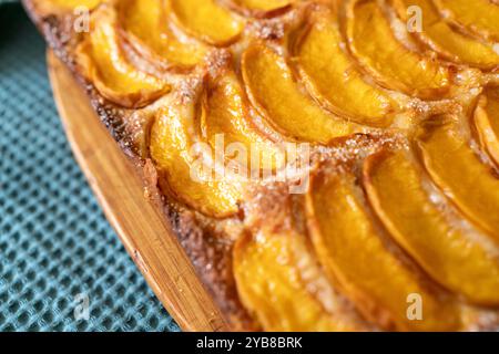 Ein Dessert aus geschnittenen Pfirsichen ist auf einem hölzernen Schneidebrett. Das Dessert ist mit Zucker bedeckt und sieht köstlich aus. Stockfoto