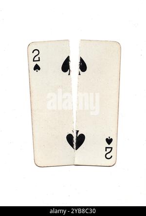 Eine alte Spielkarte, die von oben nach unten in zwei Hälften auf weißem Hintergrund zerrissen wurde. Stockfoto