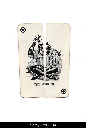 Eine alte Spielkarte, die von oben nach unten in zwei Hälften auf weißem Hintergrund zerrissen wurde. Stockfoto