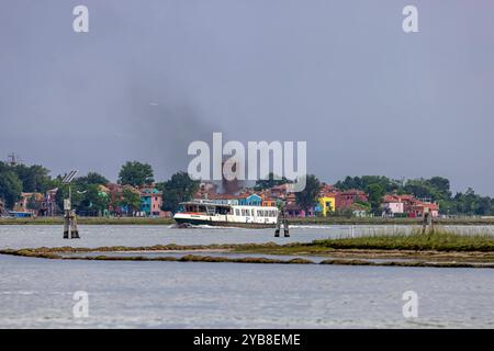 Schiff mit qualmenden Abgasen vor den farbenprächtigen Häusern von Burano. // 28.05.2024: Venedig, Venedig, Italien, Europa *** Schiff mit rauchenden Abgasen vor den bunten Häusern von Burano 28 05 2024 Venedig, Venedig, Italien, Europa Stockfoto