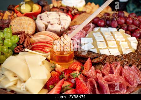 Charcuterie Cheese Board reichlich verschiedene Käsesorten Fleisch Nüsse und Früchte aus einer Seitenansicht Stockfoto