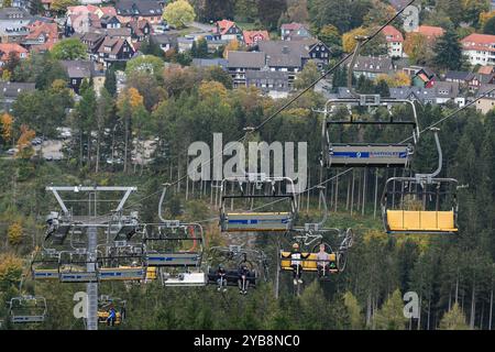 Hahnenklee, Deutschland. Oktober 2024. Mountainbiker sitzen im Sessellift auf dem Bocksberg im Harz. Die Sommersaison auf dem 727 Meter hohen Bocksberg im Landkreis Hahnenklee Goslar dauert bis zum 27.10.2024. Quelle: Swen Pförtner/dpa/Alamy Live News Stockfoto