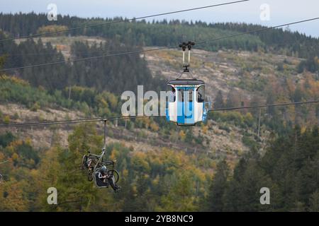 Hahnenklee, Deutschland. Oktober 2024. Mountainbiker und Wanderer sitzen in einer Gondel und Sessellift auf dem Bocksberg im Harz. Die Sommersaison auf dem 727 Meter hohen Bocksberg im Landkreis Hahnenklee Goslar dauert bis zum 27.10.2024. Quelle: Swen Pförtner/dpa/Alamy Live News Stockfoto