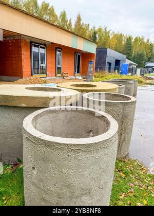 Betonabflussrohre in der Nähe eines modernen Hauses im Bau an einem bewölkten Tag. Hochwertige Fotos Stockfoto