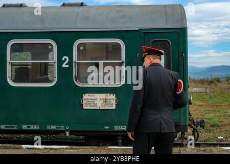 Bansko, Bulgarien - 10. Oktober 2024: Bahnhofsmeister vor einem Zug am Schmalspurbahnhof Bansko in Bulgarien. Stockfoto