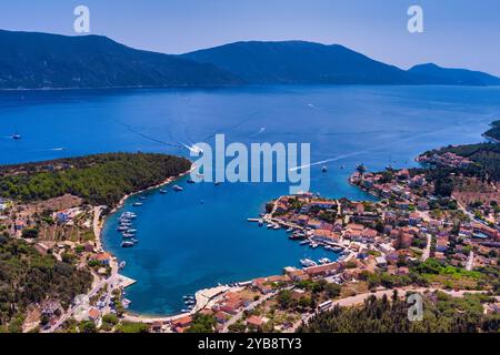 Luftaufnahme von Fiskardo, Kefalonia. Malerisches Dorf auf einer Halbinsel, umgeben von türkisfarbenem Wasser. Bunte Häuser, kleiner Strand und Boot Stockfoto