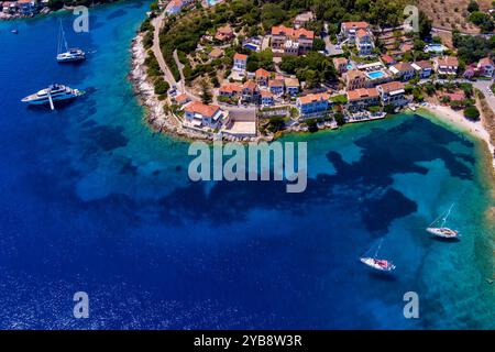 Luftaufnahme von Fiskardo, Kefalonia. Malerisches Dorf auf einer Halbinsel, umgeben von türkisfarbenem Wasser. Bunte Häuser, kleiner Strand und Boot Stockfoto