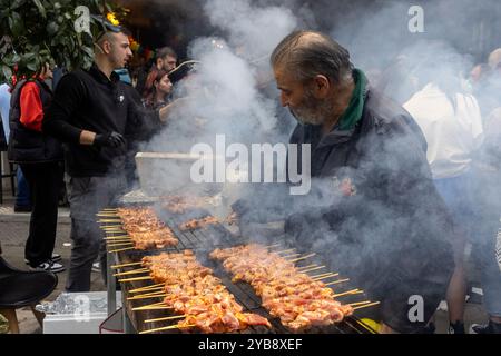 Thessaloniki, Griechenland - 7. März 2024: Während der Tsiknopempti, einer griechischen Feier, die für das Grillen von Fleisch bekannt ist, neigt ein älterer Mann zu zahlreichen Spießen auf einem sm Stockfoto