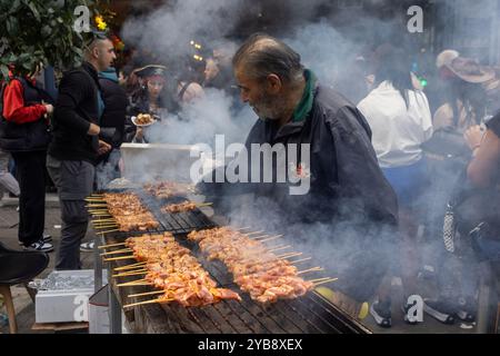 Thessaloniki, Griechenland - 7. März 2024: Während der Tsiknopempti, einer griechischen Feier, die für das Grillen von Fleisch bekannt ist, neigt ein älterer Mann zu zahlreichen Spießen auf einem sm Stockfoto