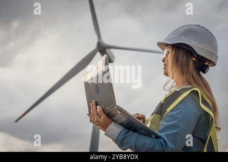 Eine erfahrene Ingenieurin überwacht Windturbinen auf ihrem Laptop, was für die Entwicklung nachhaltiger Energielösungen und die Weiterentwicklung von Technologie und entscheidend ist Stockfoto