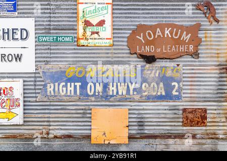 Yoakum, Texas, Usa. März 2022. Antike Schilder an einem Wellblechgebäude. Stockfoto