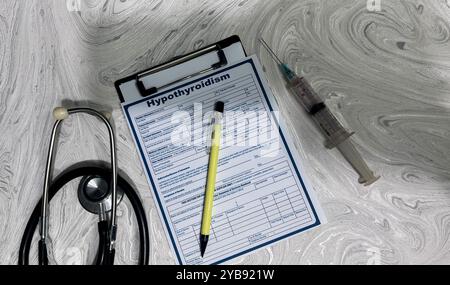 Konzept der Hypothyreose-Schrift auf Dokument isoliert auf Holztisch. Stockfoto