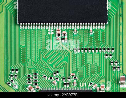 Nahaufnahme einer Hochgeschwindigkeits-Leiterplatte mit elektronischen Bauteilen. Grüne Leiterplatte mit unterschiedlicher Länge von serpentinen Leitungen zur Signalverzögerungsanpassung. Stockfoto