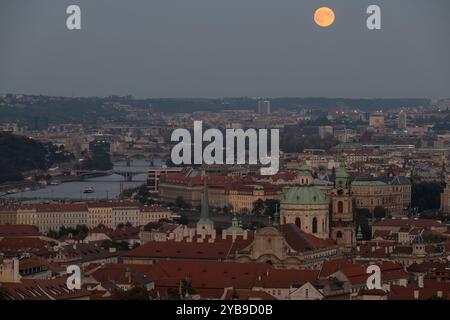 Prag, Tschechische Republik. Oktober 2024. Supermond über dem Panorama des historischen Teils der tschechischen Hauptstadt Prag. Der historische Teil von Prag ist Teil des UNESCO-Weltkulturerbes. Der Vollmond im Oktober, auch bekannt als der Jägermond, ist der größte und hellste Supermond in diesem Jahr. Quelle: SOPA Images Limited/Alamy Live News Stockfoto