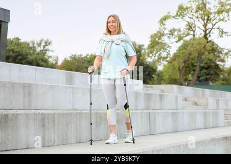 Sportliche Frau beim Nordic Walking im Freien Stockfoto